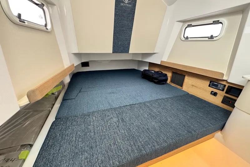 Slide: The Image of 2026 Bertram 34CC cabin interior with blue upholstery and wooden accents. - 37