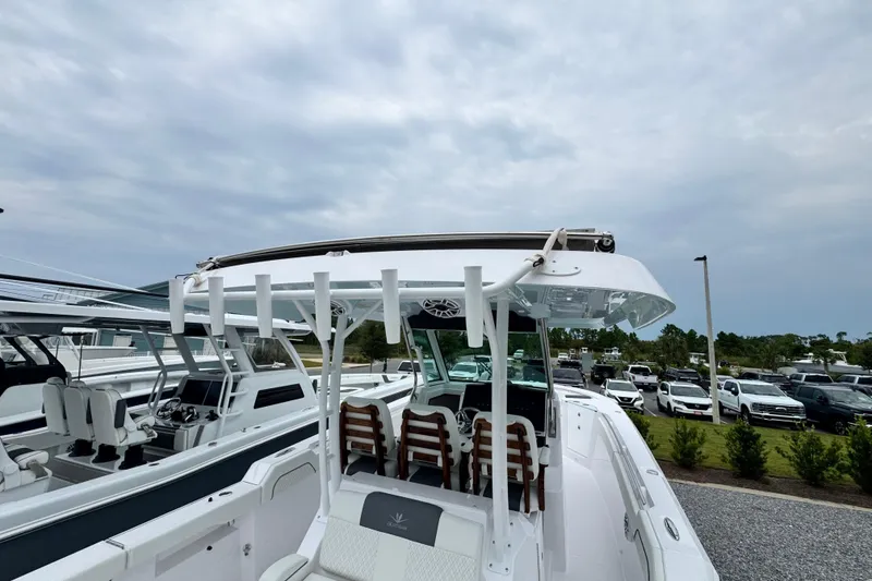 Slide: The Image of 2026 Bertram 34CC boat with sleek design, docked outdoors under cloudy sky. - 8