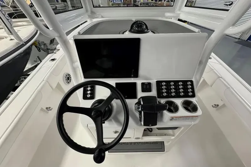 Slide: The Image of 2026 Caymas 281 HB boat dashboard with steering wheel, controls, and display screen. - 5