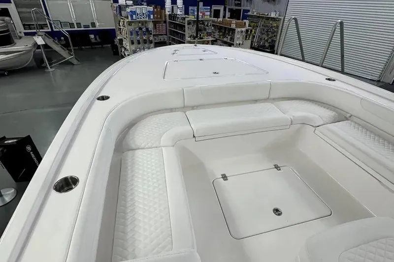 Slide: The Image of 2026 Caymas 281 HB boat interior with white cushioned seating and storage compartments. - 6