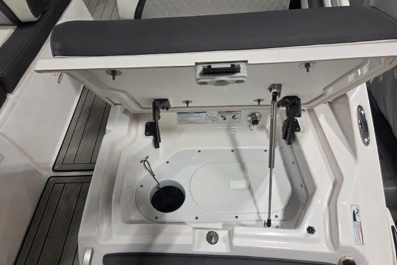 Slide: The Image of 2023 Yamaha Boats 275SDX storage compartment with open hatch and seating. - 17