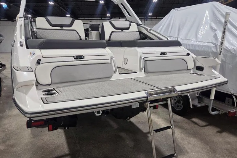 Slide: The Image of 2023 Yamaha Boats 275SDX with sleek seating and swim platform in a showroom. - 19