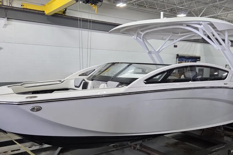 Slide: The Image of 2023 Yamaha Boats 275SDX on trailer, towed by a truck, parked outdoors. - 2