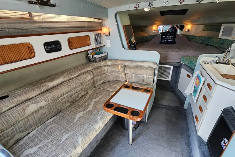 Slide: The Image of 1989 Sea Ray 280 Sundancer cabin interior with seating, table, and kitchenette. - 13