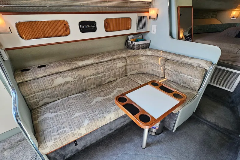 Slide: The Image of Interior of 1989 Sea Ray 280 Sundancer with cozy seating and table setup. - 14