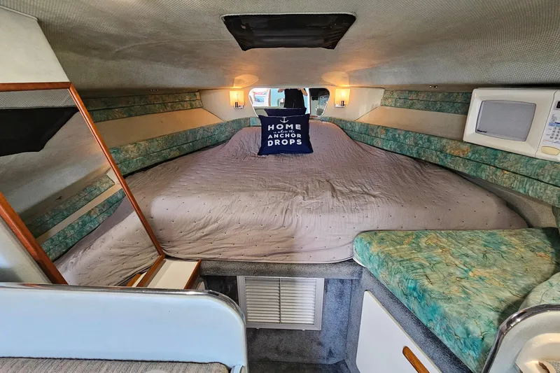 Slide: The Image of Interior of 1989 Sea Ray 280 Sundancer boat with cozy sleeping area. - 15