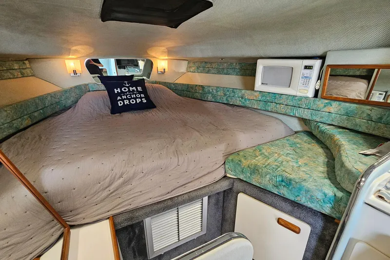 Slide: The Image of Cozy cabin interior of 1989 Sea Ray 280 Sundancer with bed, microwave, and nautical decor. - 16