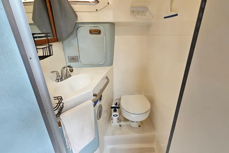Slide: The Image of 1989 Sea Ray 280 Sundancer bathroom with sink, toilet, and storage cabinet. - 20
