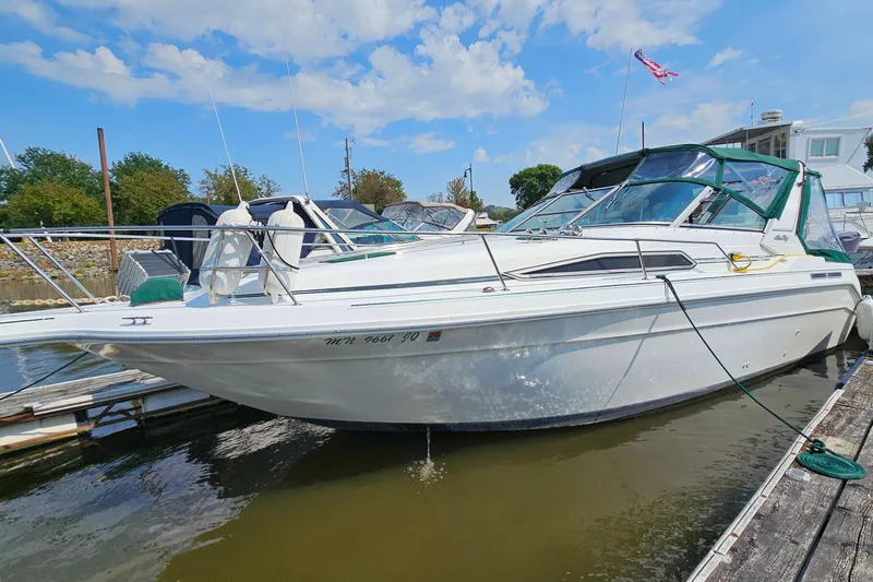 Slide: The Image of 1989 Sea Ray 280 Sundancer boat docked at marina under blue sky. - 3
