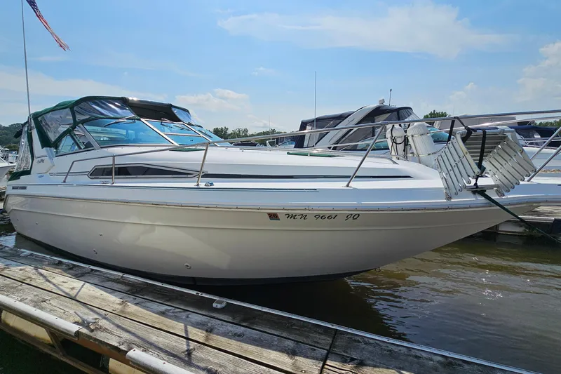 Slide: The Image of 1989 Sea Ray 280 Sundancer boat docked at marina under clear sky. - 4