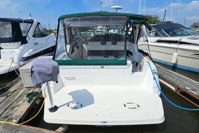 Slide: The Image of 1989 Sea Ray 280 Sundancer docked, featuring green canopy and spacious deck area. - 5