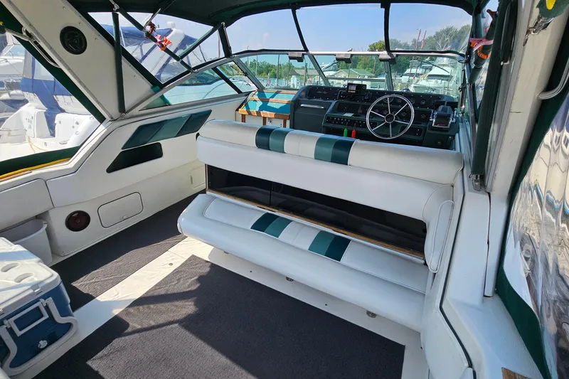 Slide: The Image of Interior of 1989 Sea Ray 280 Sundancer boat with white seating and steering wheel. - 6