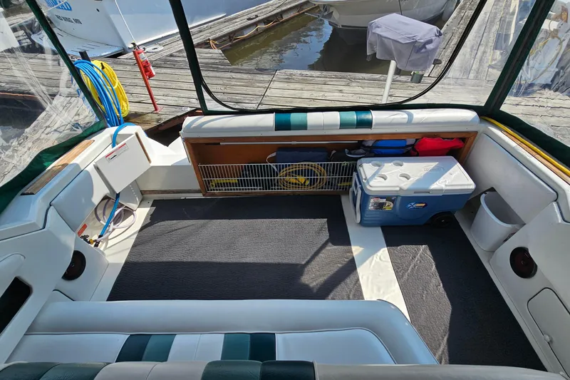 Slide: The Image of Interior of 1989 Sea Ray 280 Sundancer boat with seating, cooler, and dock view. - 8