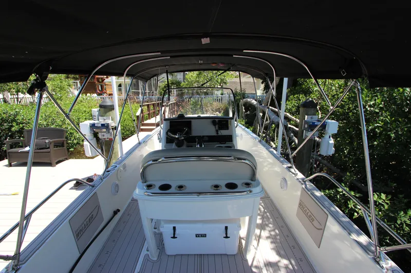 Slide: The Image of 2017 Boston Whaler 270 Dauntless boat interior with canopy, docked in a lush setting. - 12