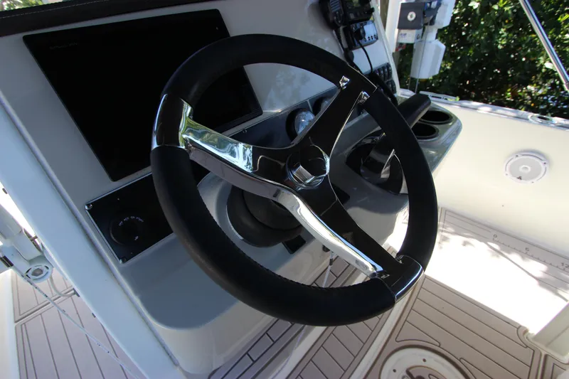 Slide: The Image of Steering wheel of 2017 Boston Whaler 270 Dauntless boat, featuring modern controls and dashboard. - 16