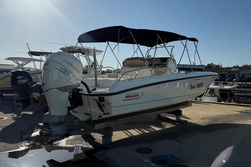 Slide: The Image of 2017 Boston Whaler 270 Dauntless boat with canopy, docked at marina. - 4