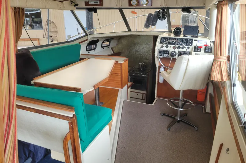 Slide: The Image of 1981 Bayliner 3270 Explorer interior with helm, dining area, and green seating. - 11