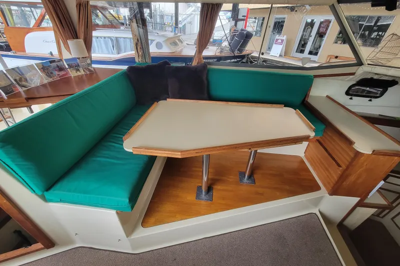 Slide: The Image of Interior of 1981 Bayliner 3270 Explorer with green cushioned seating and wooden table. - 12