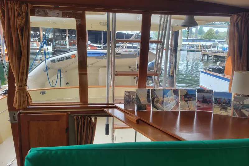 Slide: The Image of Interior view of 1981 Bayliner 3270 Explorer with marina backdrop and photo display. - 13