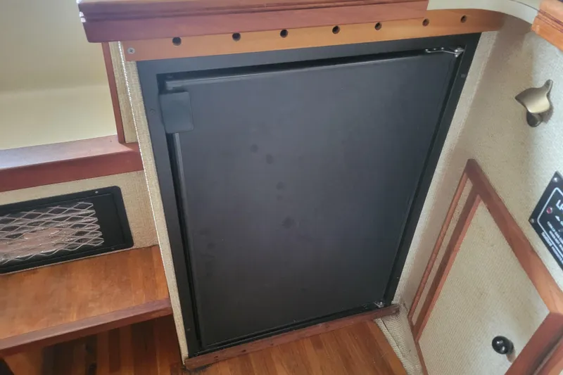 Slide: The Image of 1981 Bayliner 3270 Explorer interior with a closed black cabinet door. - 18