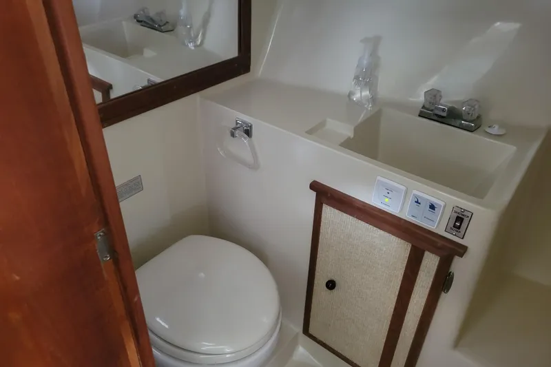 Slide: The Image of 1981 Bayliner 3270 Explorer bathroom with toilet, sink, and wooden accents. - 20