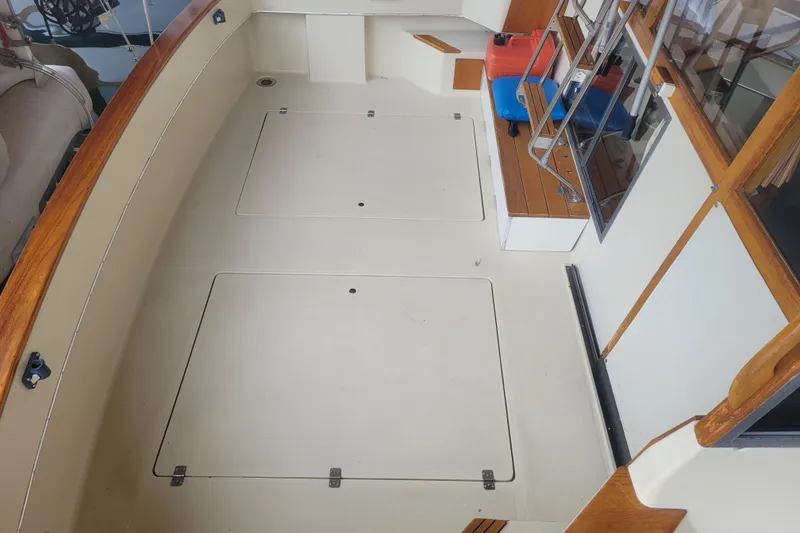 Slide: The Image of 1981 Bayliner 3270 Explorer boat deck with storage hatches and wooden trim. - 5