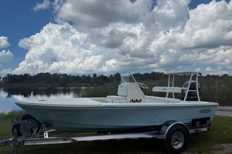 Slide: The Image of 2026 Hewes 16 Redfisher boat on trailer by a lake under cloudy sky. - 10