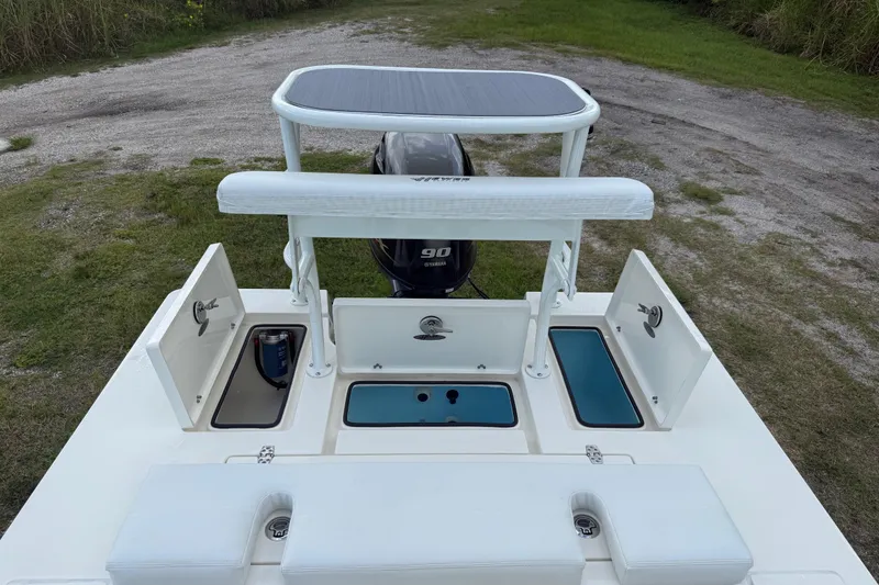 Slide: The Image of 2026 Hewes 16 Redfisher boat with open storage compartments and Yamaha 90 engine. - 24