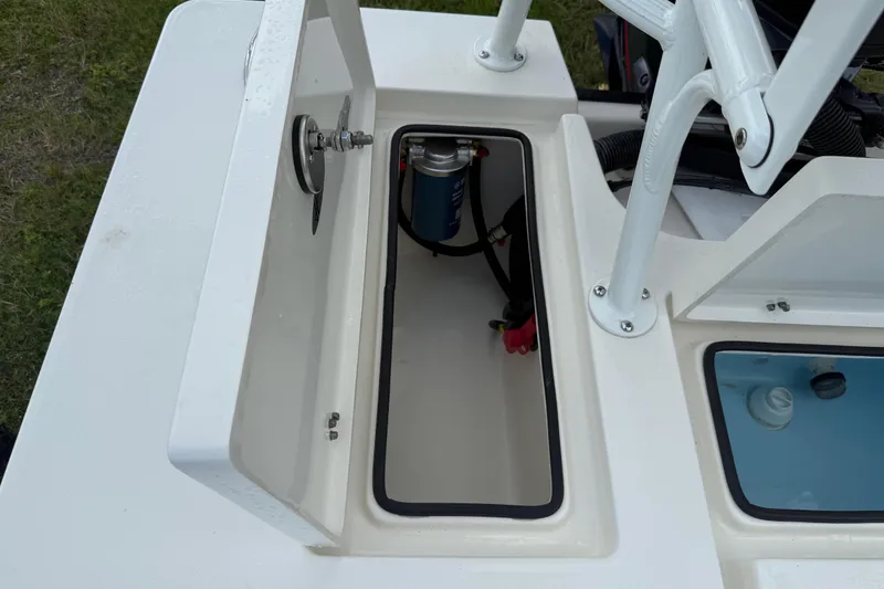 Slide: The Image of 2026 Hewes 16 Redfisher boat compartment with open hatch and visible components. - 25