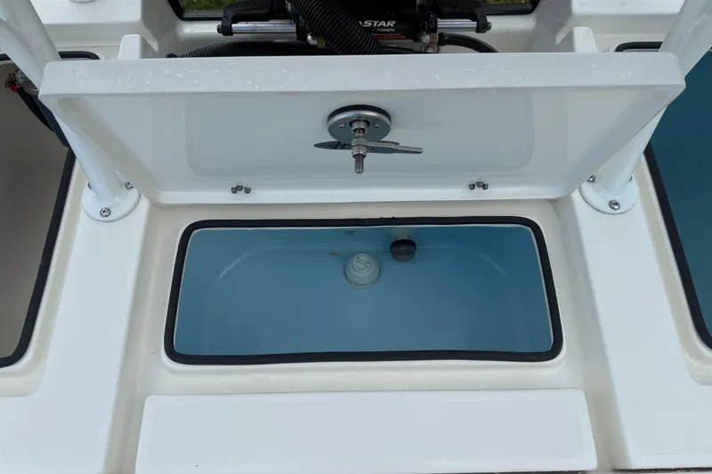 Slide: The Image of 2026 Hewes 16 Redfisher boat livewell with open lid and water inside. - 26