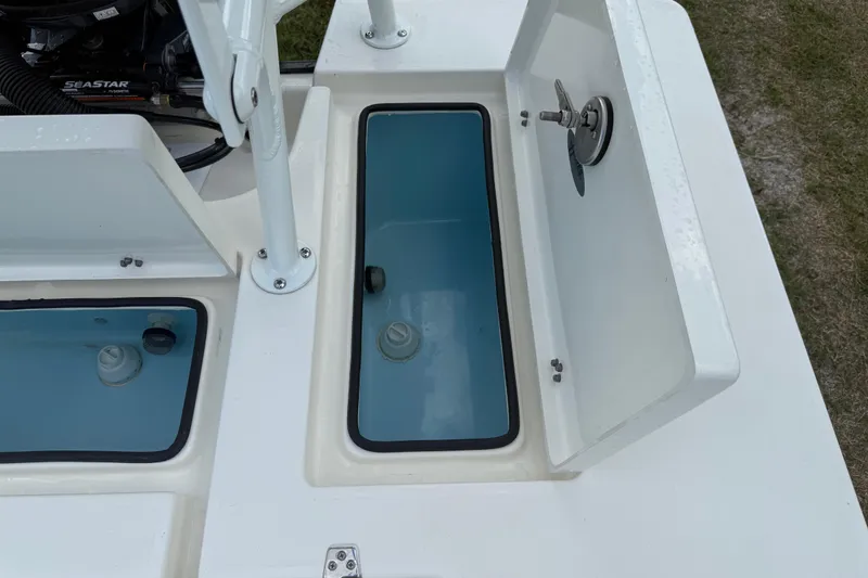 Slide: The Image of 2026 Hewes 16 Redfisher boat storage compartments with open lids, showcasing interior details. - 27