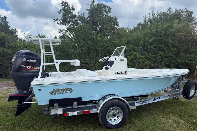 Slide: The Image of 2026 Hewes 16 Redfisher boat on trailer with Yamaha engine, parked outdoors. - 3