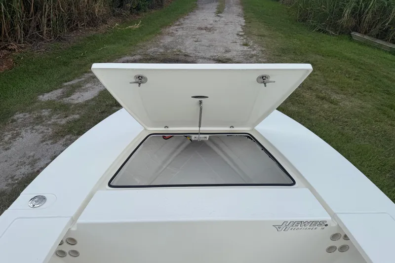 Slide: The Image of 2026 Hewes 16 Redfisher boat with open storage compartment on grassy path. - 30
