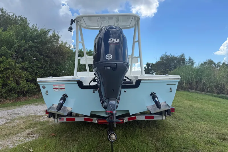 Slide: The Image of 2026 Hewes 16 Redfisher boat with 90 horsepower engine on trailer, grassy background. - 4