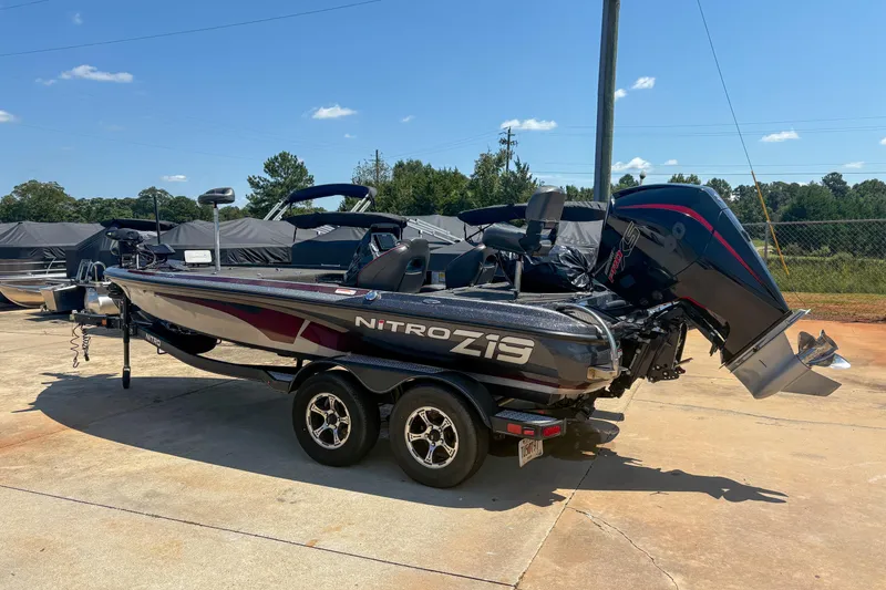 Slide: The Image of 2021 Nitro Z19 boat on trailer, parked outdoors under clear blue sky. - 0