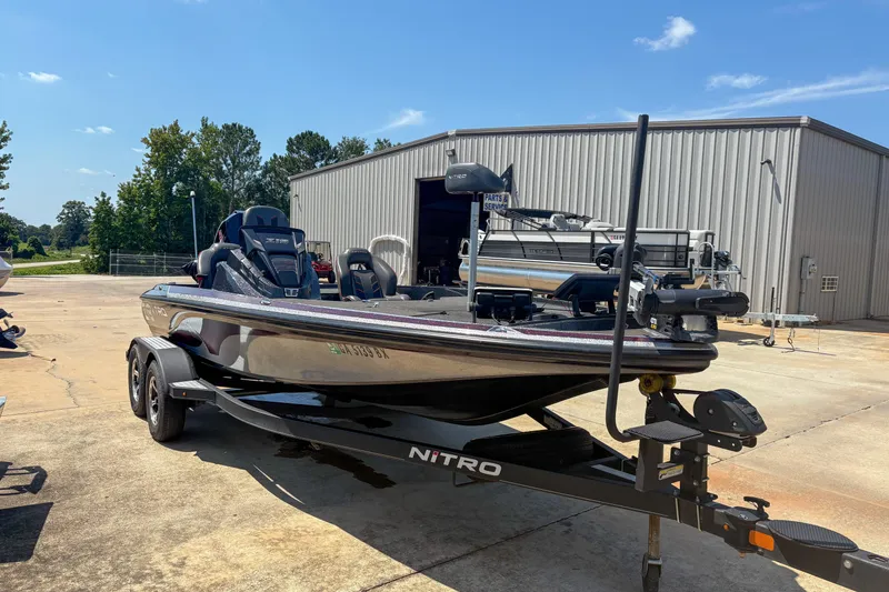 Slide: The Image of 2021 Nitro Z19 boat on trailer, parked outside a metal building under clear skies. - 1