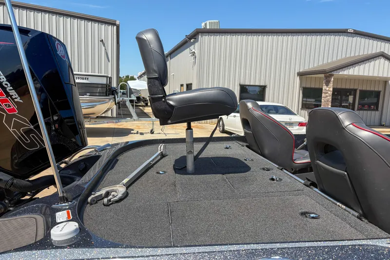 Slide: The Image of 2021 Nitro Z19 boat with elevated seat and Mercury engine, parked near metal building. - 12