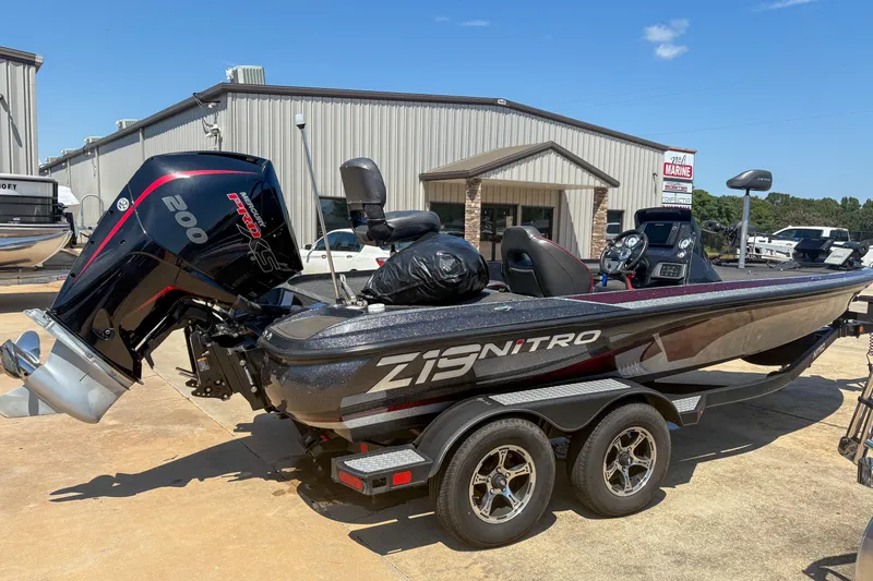 Slide: The Image of 2021 Nitro Z19 boat with powerful engine, parked outside a marine dealership. - 2