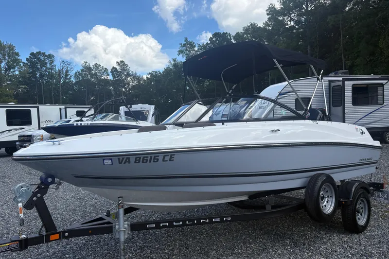 The Image of 2020 Bayliner 170 Bowrider boat on trailer, parked outdoors under a blue sky. - 1