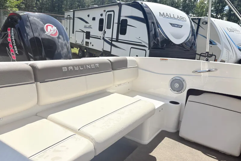 Slide: The Image of 2020 Bayliner 170 Bowrider interior with seating, Mercury engine, and RVs in background. - 13