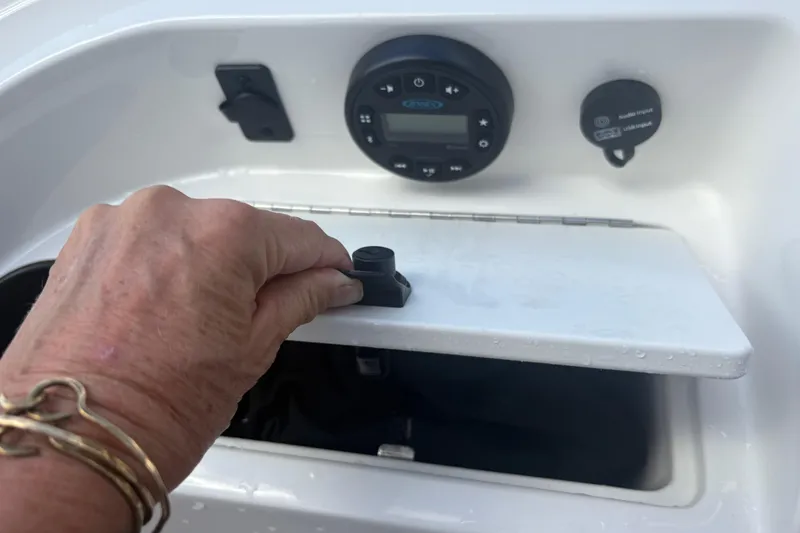Slide: The Image of Hand opening compartment on 2020 Bayliner 170 Bowrider boat dashboard. - 4