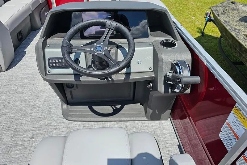 Slide: The Image of 2026 Sun Tracker Party Barge 20 DLX helm with steering wheel and control panel. - 17