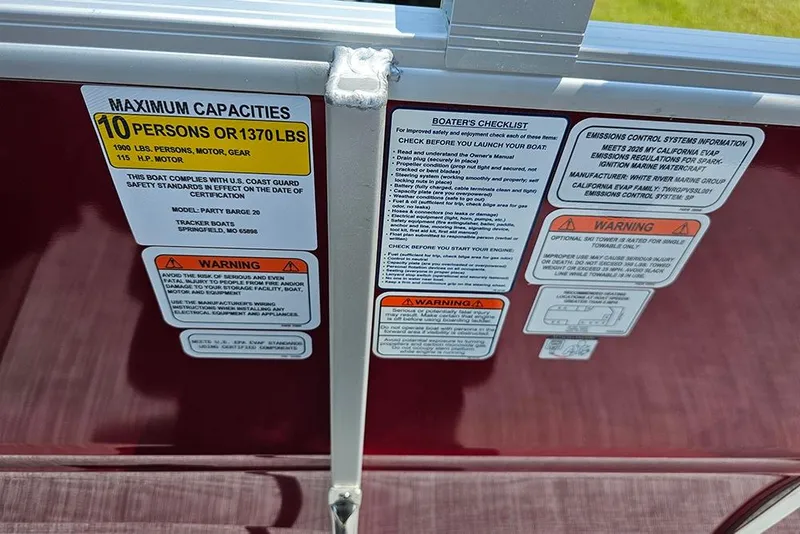 Slide: The Image of 2026 Sun Tracker Party Barge 20 DLX capacity and safety labels on boat interior. - 19