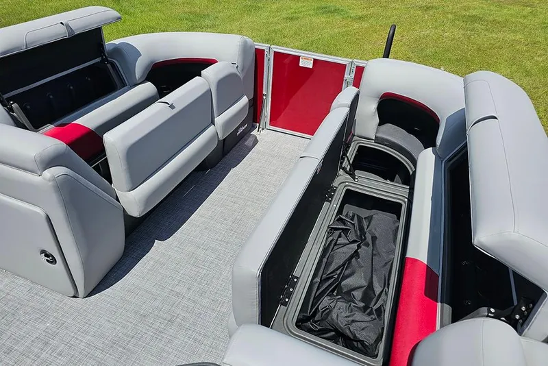 Slide: The Image of 2026 Sun Tracker Party Barge 20 DLX interior with open storage compartments and gray seating. - 22