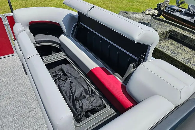Slide: The Image of 2026 Sun Tracker Party Barge 20 DLX with open storage compartment and cushioned seating. - 23