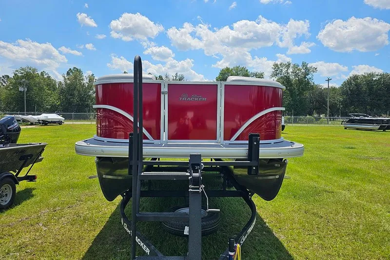Slide: The Image of 2026 Sun Tracker Party Barge 20 DLX pontoon boat on grassy field under blue sky. - 4
