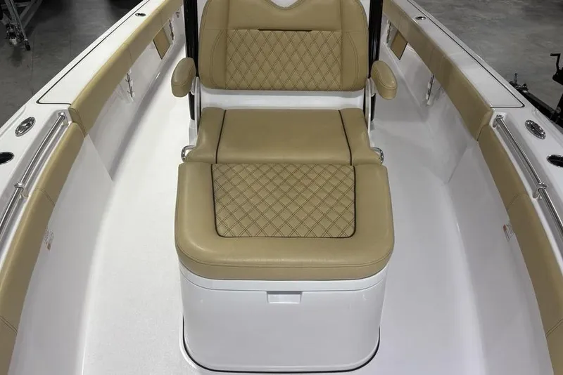 Slide: The Image of 2025 Sportsman Masters 267OE Bay Boat interior with tan cushioned seating. - 12