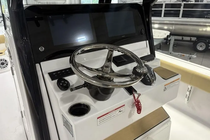 Slide: The Image of 2025 Sportsman Masters 267OE Bay Boat helm with dual screens and stainless steel steering wheel. - 13