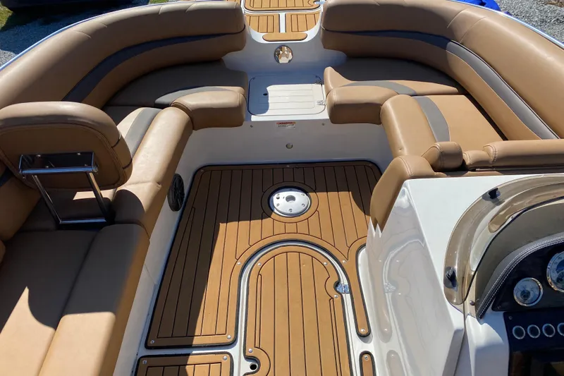 Slide: The Image of 2022 Starcraft Star Step 221 E I/O boat interior with tan seating and wood-style flooring. - 13