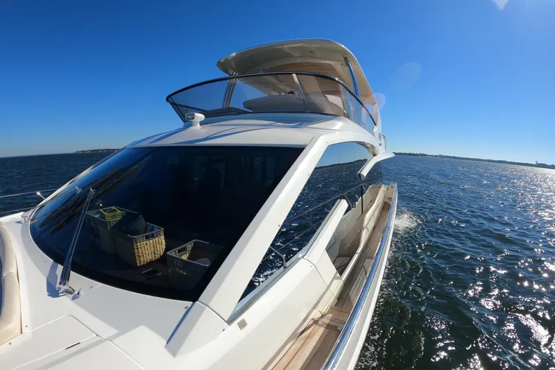 Slide: The Image of Luxurious 2016 Absolute 72 FLY yacht cruising on open water under clear blue skies. - 141